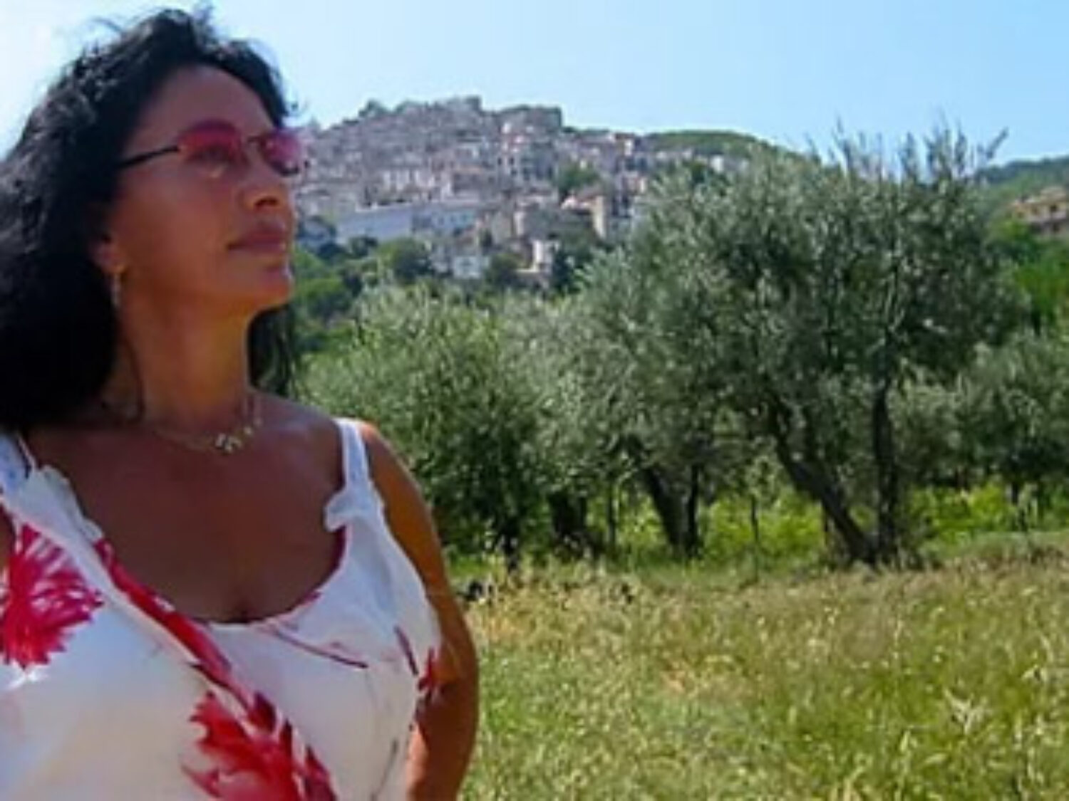 Maria Pelligrini looking into the distance with trees and a small town in the background.
